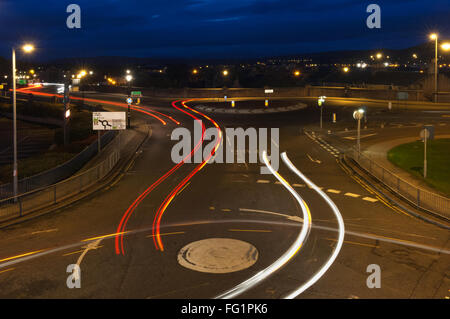 Auto sentieri di luce di notte, in corrispondenza di una serie di rotatorie a Inverness, Scotland. Foto Stock