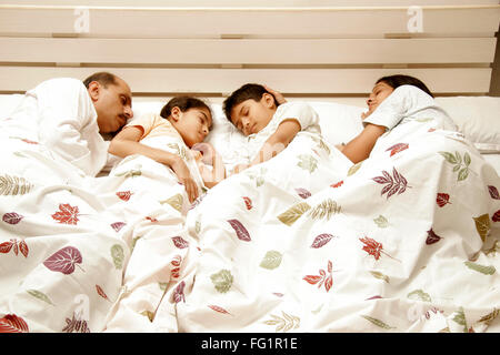 South Asian Indian famiglia ideale avente suono addormentato sul letto signor#86E,191,686d,189 Foto Stock