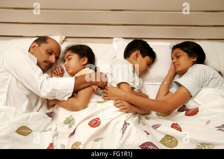 South Asian Indian famiglia ideale coccole ogni altro avente suono addormentato sul letto signor#686E, 191,686d,189 Foto Stock
