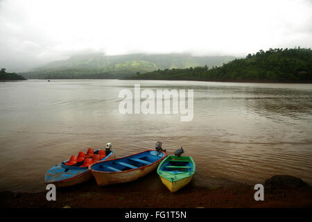 Monsoon , paesaggio con tre barche colorate a Shiva sagar lago , Tapola , Maharashtra , India Foto Stock