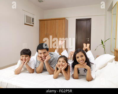 I genitori con bambini sdraiato sul letto in camera da letto signor#702R,MR#702S,MR#702T,MR#702U Foto Stock