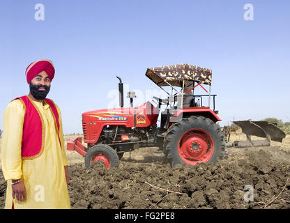 La religione Sikh l uomo con il contadino con trattore in campo il signor#779A Foto Stock