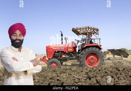 La religione Sikh l uomo con il contadino con trattore in campo il signor#779A Foto Stock