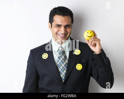 Spilla Smiley sul mantello di executive che mostra smiley sfera signor#779K Foto Stock