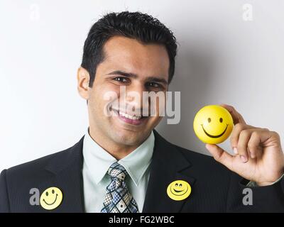 Spilla Smiley sul mantello di executive che mostra smiley sfera signor#779K Foto Stock