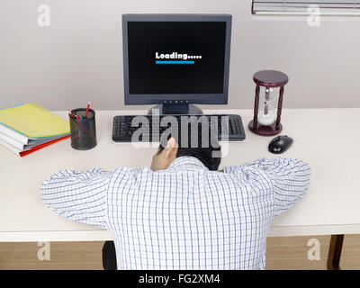 Executive in appoggio sul banco di carico di lavoro sul computer - Modello di Rilascio # 779K Foto Stock