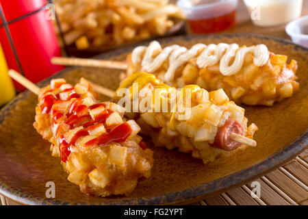 Delizioso croccante di Stile coreano chunky cani di mais con pastella e patate fritte. Foto Stock