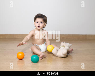 Baby indossa pannolino giocando con il giocattolo ; signor#779N Foto Stock