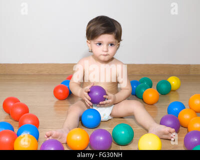 Baby indossa pannolino giocando con coloratissime palle ; signor#779N Foto Stock