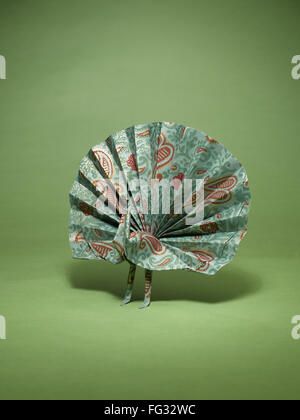 uccello di carta di pavone origami su sfondo verde Foto Stock