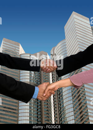 I dirigenti grattacielo di handshaking in background MR Foto Stock