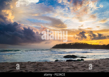 Golden tramonto sulla spiaggia deserta con colorati sky e scenic cloudscape durante il monsone di tempo. Complesso turistico di Mirissa, Sri Lanka, Foto Stock