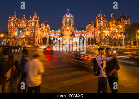 Indian uomini prendendo un selfie fuori dalla stazione ferroviaria Chhatrapati Shivaji Terminus (CST) , precedentemente noto come Victoria Terminus,Mumbai Foto Stock