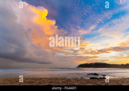 Golden tramonto sulla spiaggia deserta con colorati sky e scenic cloudscape durante il monsone di tempo. Complesso turistico di Mirissa, Sri Lanka, Foto Stock