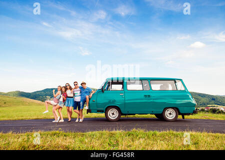 Giovani amici con camper, natura verde e blu cielo Foto Stock