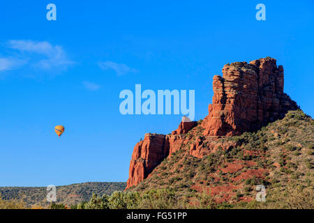 Mongolfiera in volo, sopraffatte in confronto al massiccio di arenaria rossa e la formazione nelle vicinanze, a Sedona, in Arizona Foto Stock