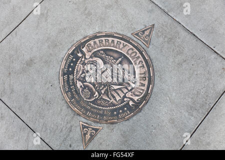 Medaglione di bronzo e frecce incorporato nella marcatura sul marciapiede di Barbary Coast Trail del sito storico di San Francisco, CA Foto Stock