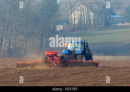 Trattore con un cultipacker rulli sul campo a molla Foto Stock