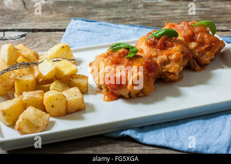 Baccalà con salsa di pomodoro e profonda di patate fritte sul vassoio Foto Stock