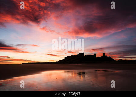 Il castello di Bamburgh visto dalla Spiaggia Bamburgh all'alba, Bamburgh, Northumberland, England, Regno Unito Foto Stock