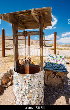 Un pozzo accanto a Tom Kelly bottiglia casa nella città fantasma di riolite, Nevada Foto Stock