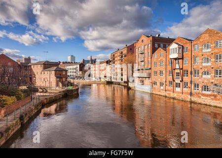 Il fiume Aire nel centro di Leeds, West Yorkshire, Inghilterra, Regno Unito, con edifici di appartamenti su entrambi i lati, alcuni convertiti ware Foto Stock