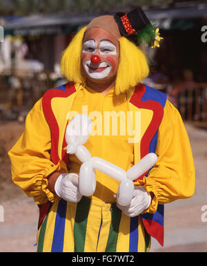 Clown colorati holding palloncino modellato, Berkshire, Inghilterra, Regno Unito Foto Stock