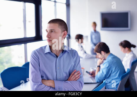 Uomo d'affari su una riunione in offce con colleghi in background Foto Stock