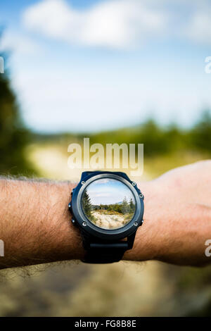 La tecnologia indossabile, uomo prendendo foto con smartwatch telecamera in montagna. Smart guarda la fotografia con app Fotocamera applicazione. i Foto Stock