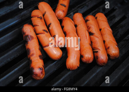 Molti grigliate di hotdog su una griglia di estate Foto Stock