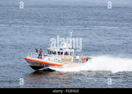 Accelerando la barca con gunner pronto a far fuoco di guardacoste degli Stati Uniti Foto Stock