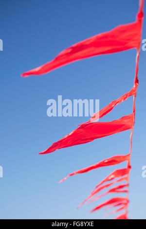Red Flag triangolare sopra beach in vento Foto Stock