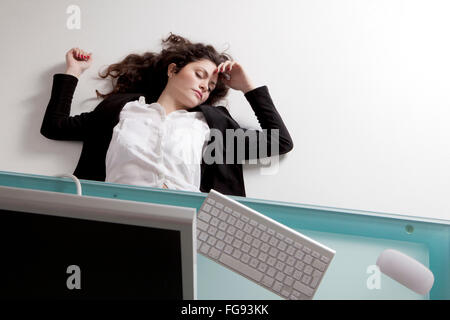 Donna sdraiata sul pavimento in ufficio Foto Stock