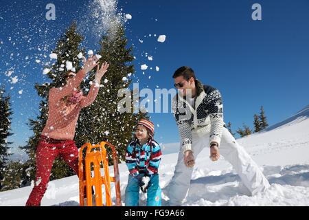 Famiglia avente il divertimento sulla neve fresca in inverno Foto Stock