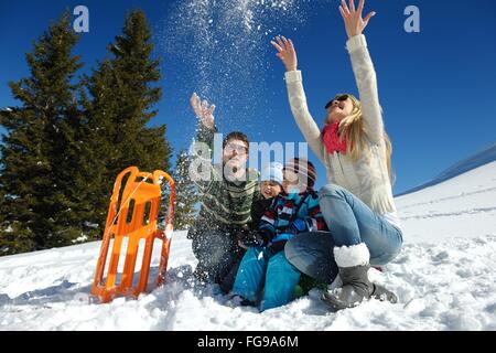 Famiglia avente il divertimento sulla neve fresca in inverno Foto Stock