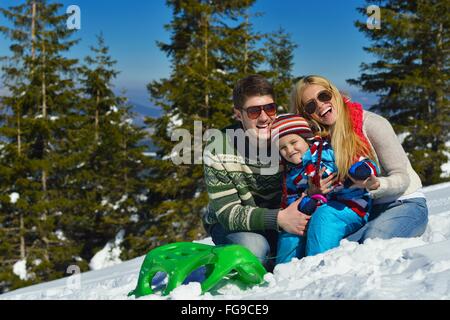 Famiglia avente il divertimento sulla neve fresca in inverno Foto Stock