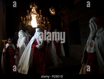 I penitenti incappucciati accompagnare l immagine della Vergine della solitudine (Virgen de la Soledad) durante una pasqua settimana santa Foto Stock