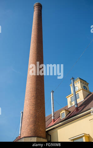 Rosso alta ciminiera in mattoni nella tradizionale birreria Foto Stock