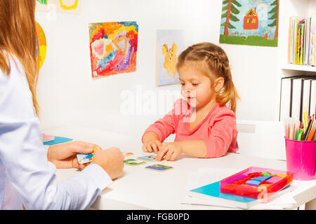 Bambina di prendere le carte dal tavolo in classe Foto Stock