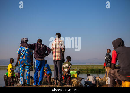 I pescatori si riuniscono per scaricare il loro pesce in la mattina presto il sole, sulle rive del lago di Hawassa, Etiopia Africa Foto Stock
