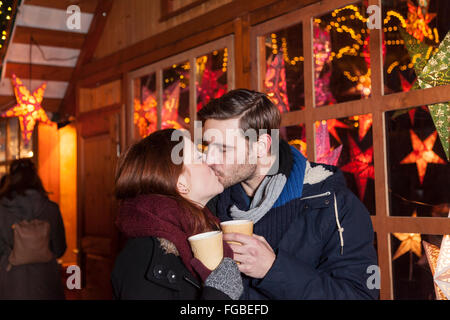 Giovane kissing sul mercato di natale Foto Stock