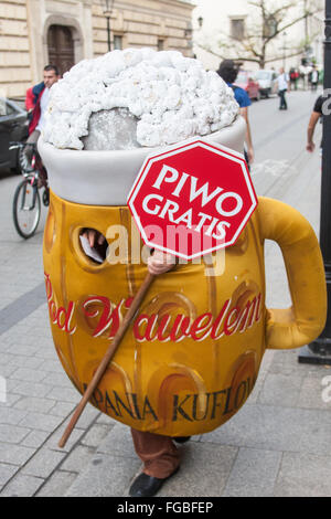 Local vestito come un boccale di birra con birra gratis segno distribuivano tagliandi per birra gratis nella città vecchia di Cracovia,Polonia,l'Europa. Foto Stock