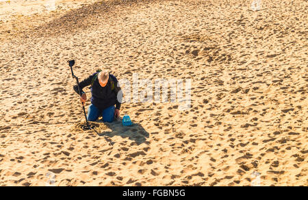 Uomo con rilevatore di metalli sulla sabbia a Swanage Foto Stock