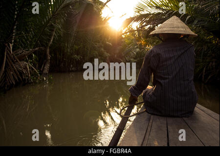 Una donna pagaie una barca in Vietnam Foto Stock