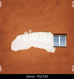 Abbandonato incrinato un muro di mattoni con una finestra Foto Stock