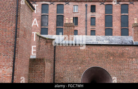 La parola tate a grandi lettere sul lato del restaurato costruiti in mattoni Albert Dock depositi nella scatola di Liverpool Tate Modern Foto Stock