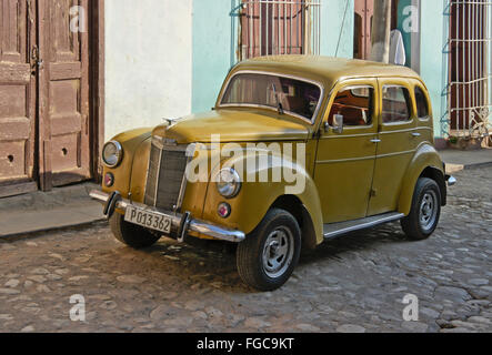 Vecchia Ford giallo parcheggiato sulla strada di ciottoli, Old Trinidad, Cuba Foto Stock