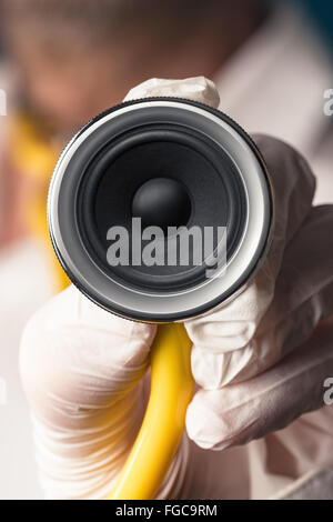 Un medico tenendo uno stetoscopio con un altoparlante in mano Foto Stock