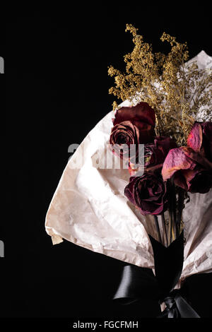 Rosso essiccato bouquet di rose shot vicino fino in fondo nero e lo spazio contenuto pronto Foto Stock