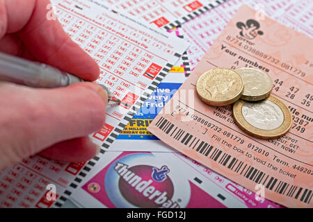 Primo piano di uomo persona che compila nella scelta dei numeri Lotto Tagliandi e biglietti per la lotteria nazionale Inghilterra UK Regno Unito Gran Bretagna Foto Stock